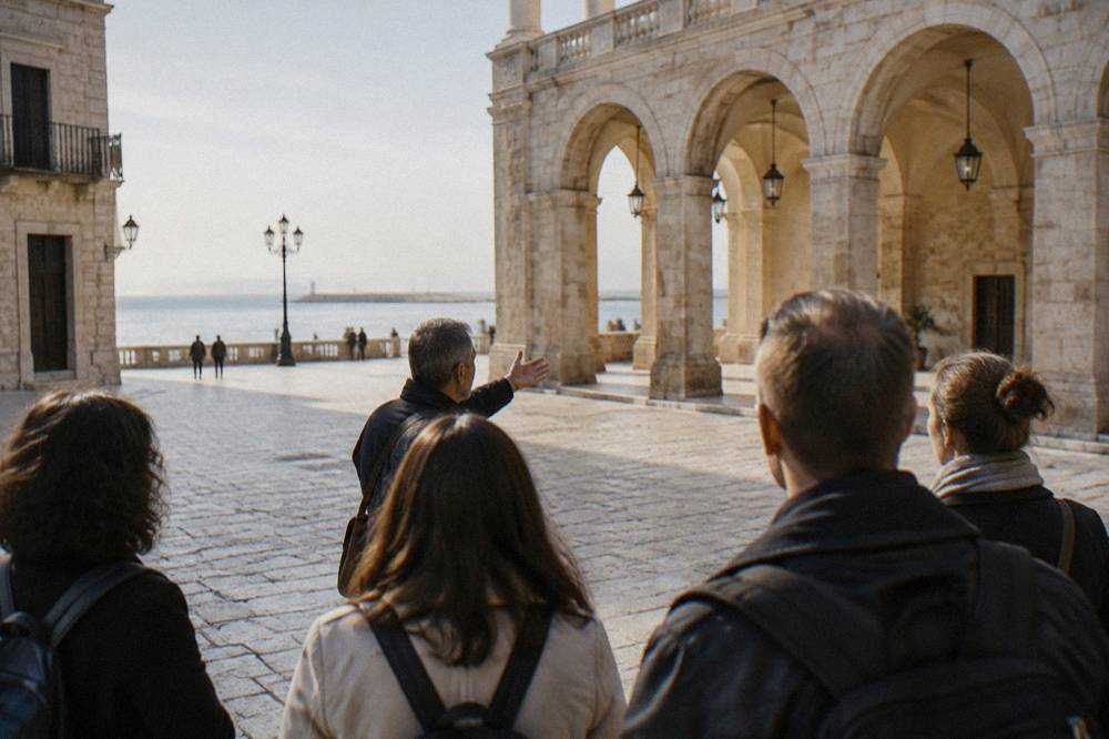 A guided walking tour group moving through the lanes of Bari Vecchia past old stone buildings.
