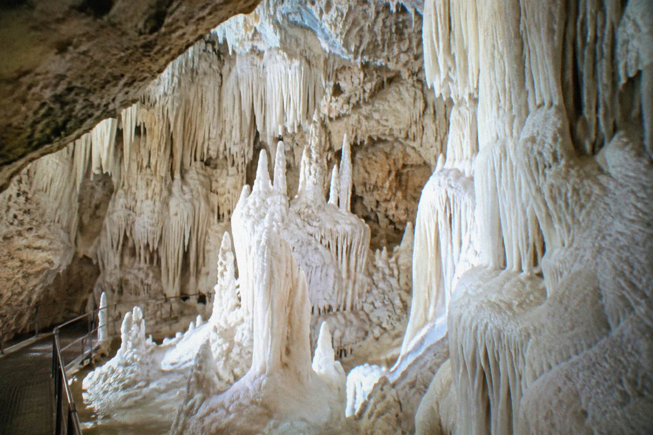 Chamber of pure white alabaster cave formations glowing under soft light