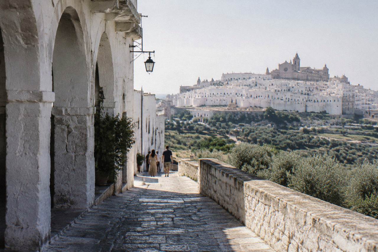 Dazzling white hill town on a ridge above silvery olive groves with a rose-windowed cathedral at the top