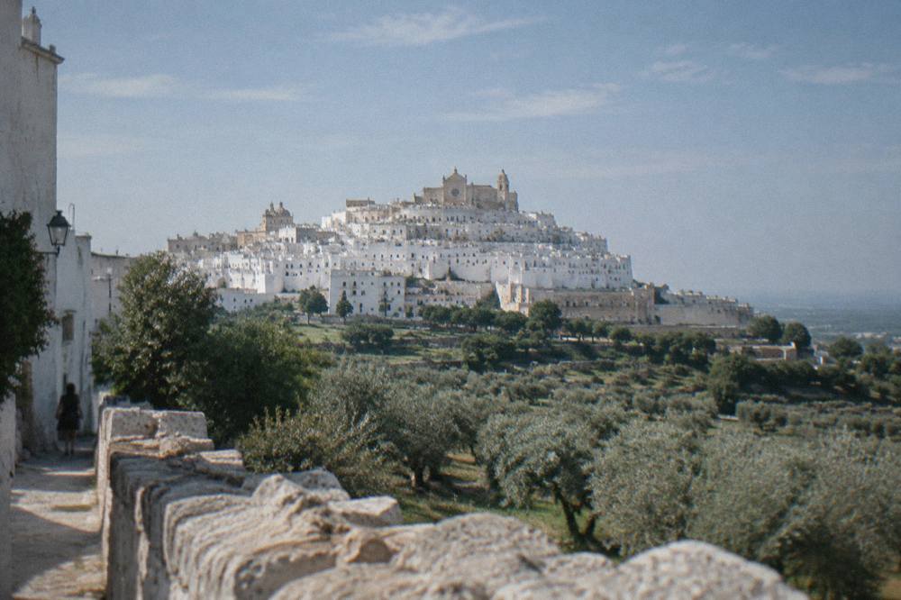 Dazzling white hill town on a ridge above silvery olive groves with a rose-windowed cathedral at the top