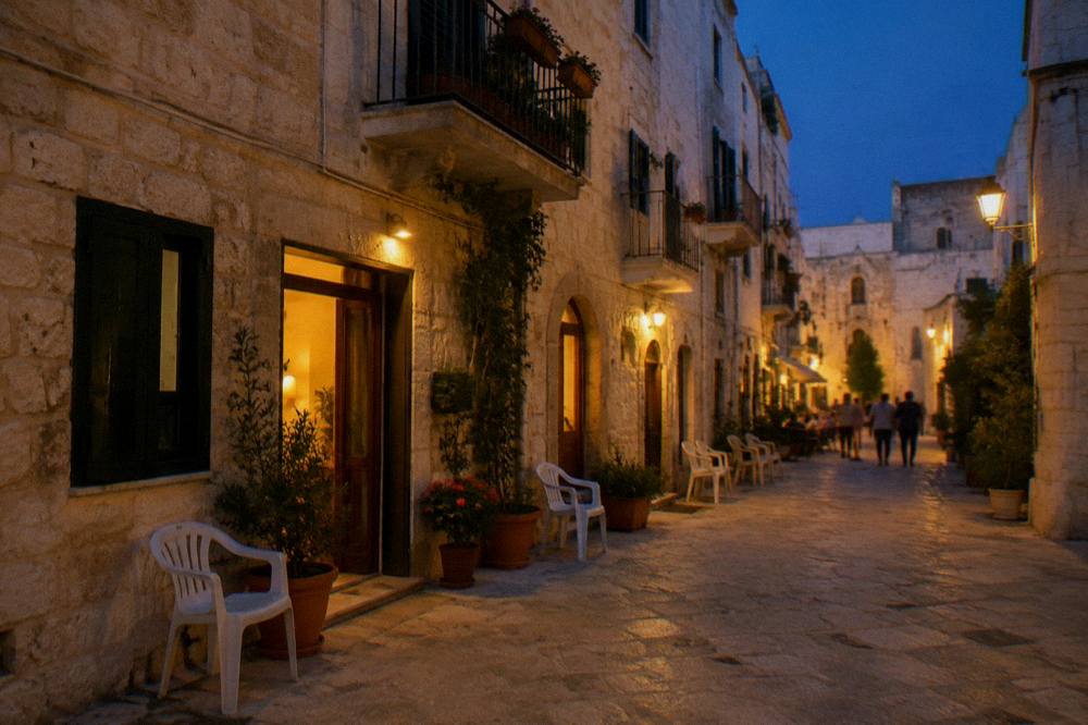Old town lane at blue hour with warm light glowing from doorways and chairs set outside