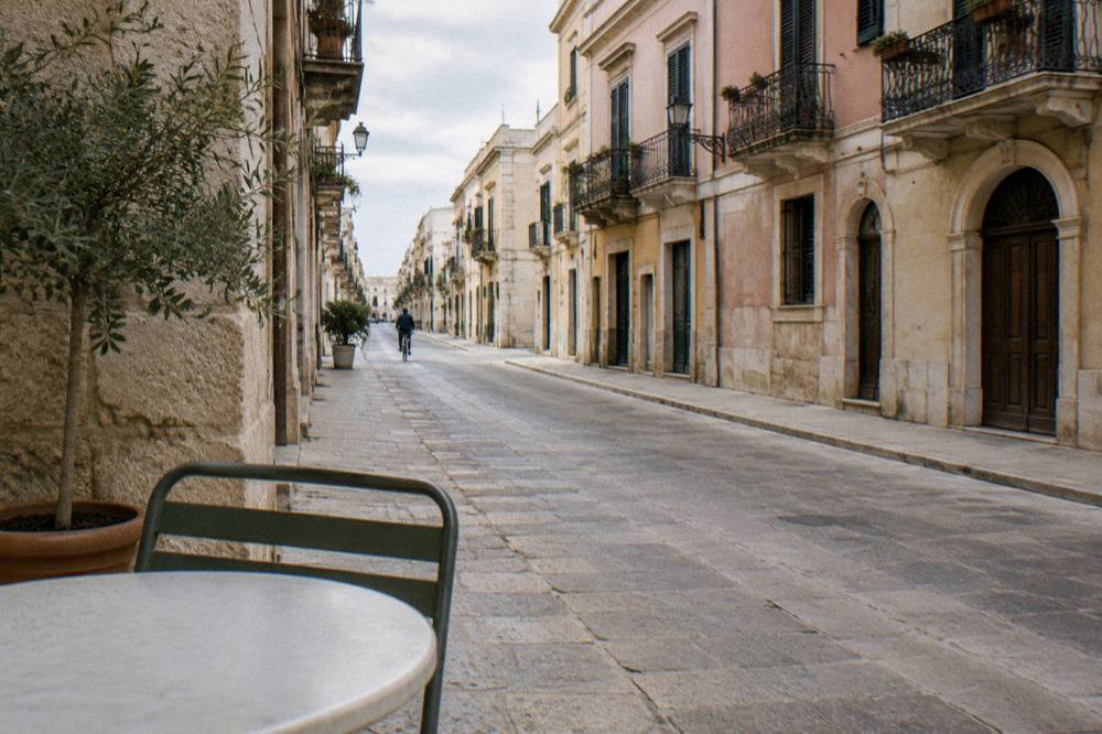 Elegant street with wrought-iron balconies and pastel stucco facades on a quiet morning