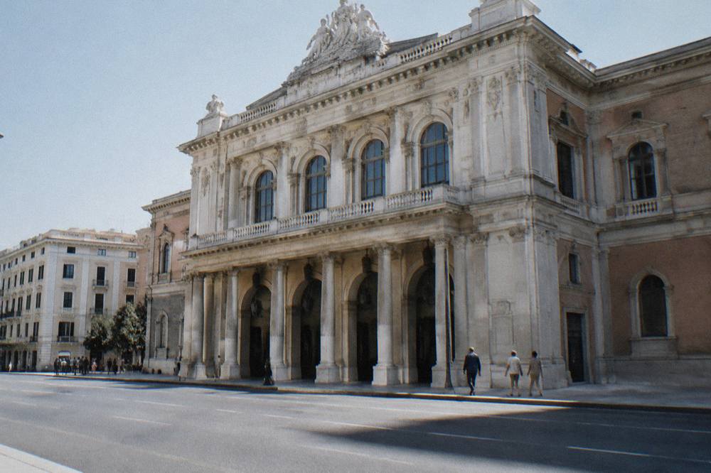 Grand neoclassical opera house with a cream facade, a columned portico and tall arched windows on a wide street