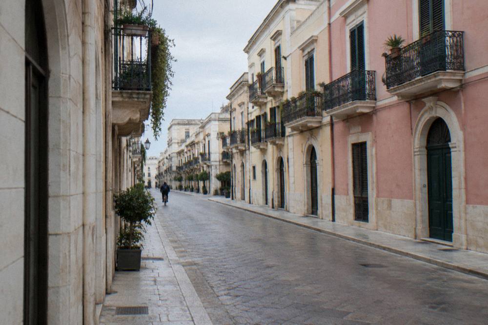 Elegant street with wrought-iron balconies and pastel stucco facades on a quiet morning