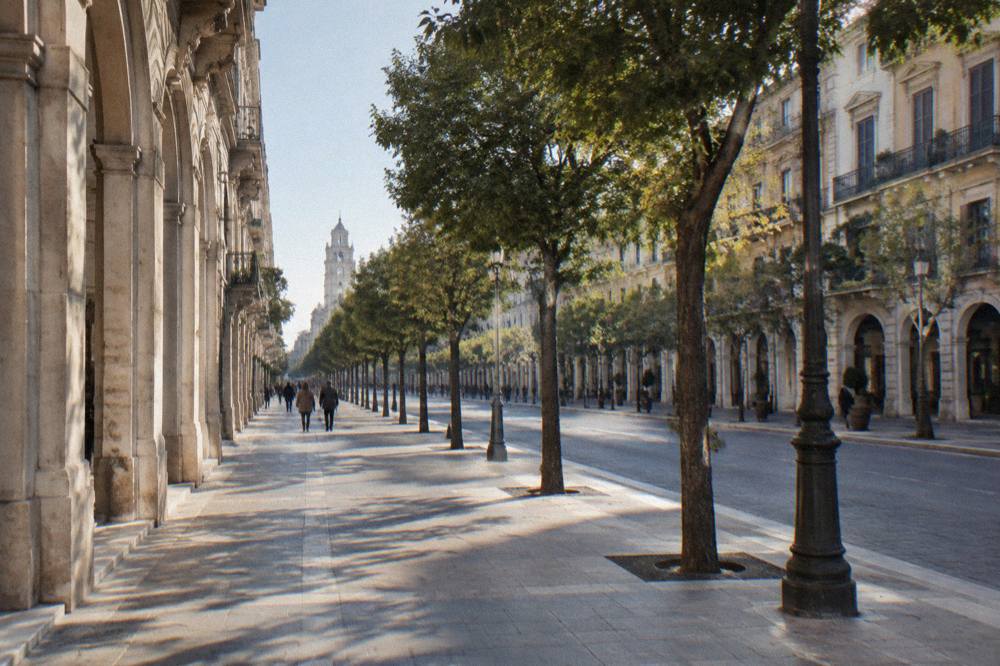 Long straight tree-lined boulevard of neoclassical buildings with arcaded ground floors