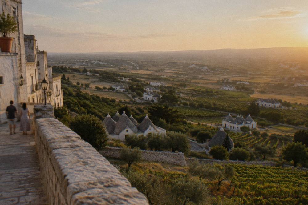 Valley of vineyards, dry-stone walls and conical-roofed farm houses seen from a hill town