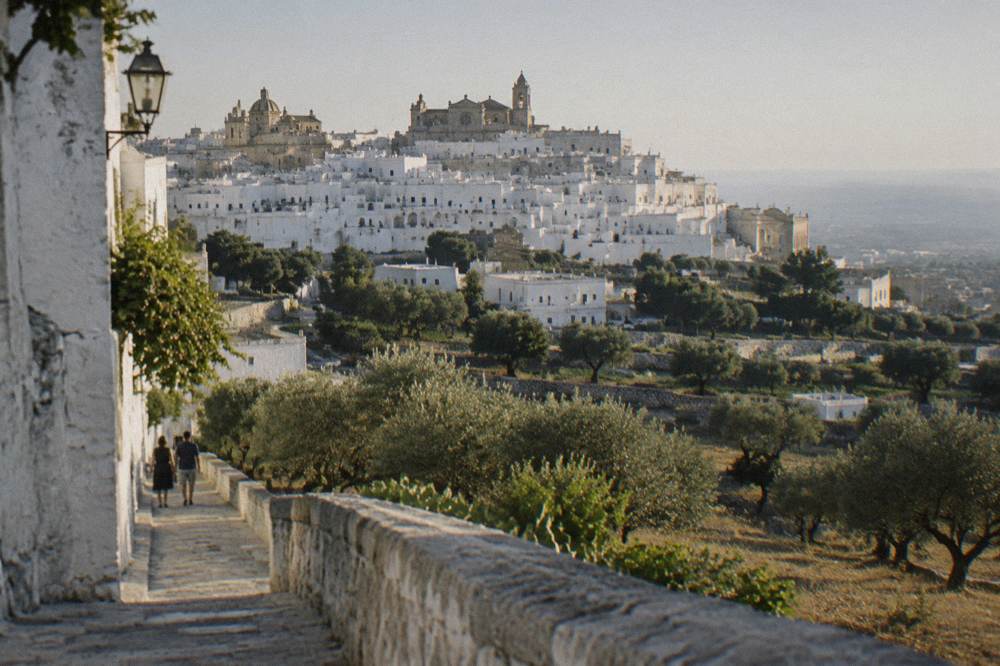 Dazzling white hill town on a ridge above silvery olive groves with a rose-windowed cathedral at the top