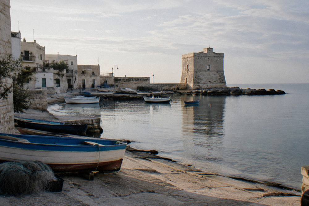 Tiny fishing hamlet with a small stone harbour, a squat old tower and boats pulled onto a slipway