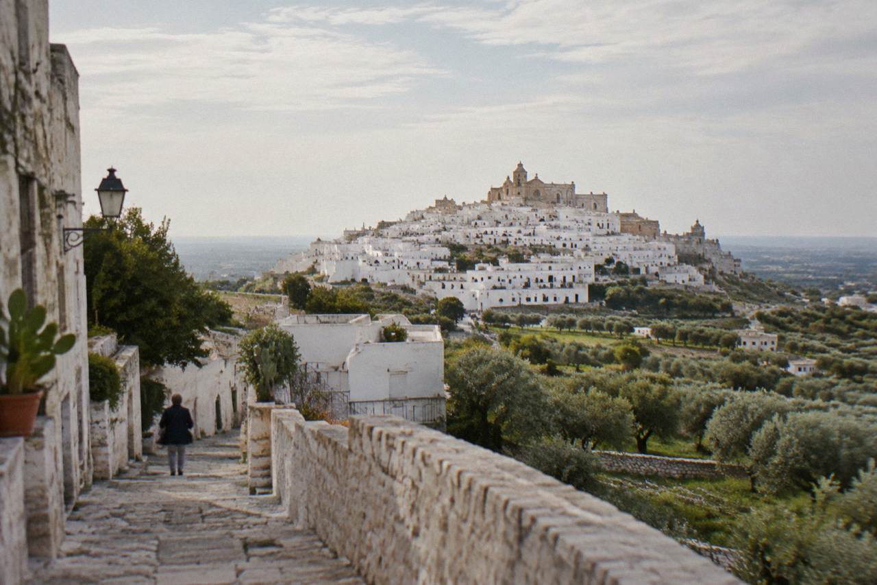 Dazzling white hill town on a ridge above silvery olive groves with a rose-windowed cathedral at the top