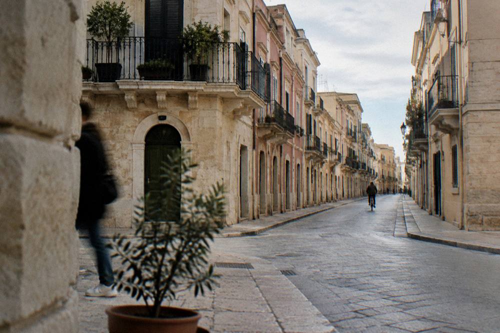 Elegant street with wrought-iron balconies and pastel stucco facades on a quiet morning