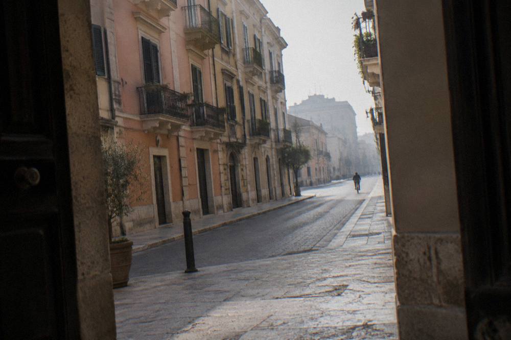 Elegant street with wrought-iron balconies and pastel stucco facades on a quiet morning