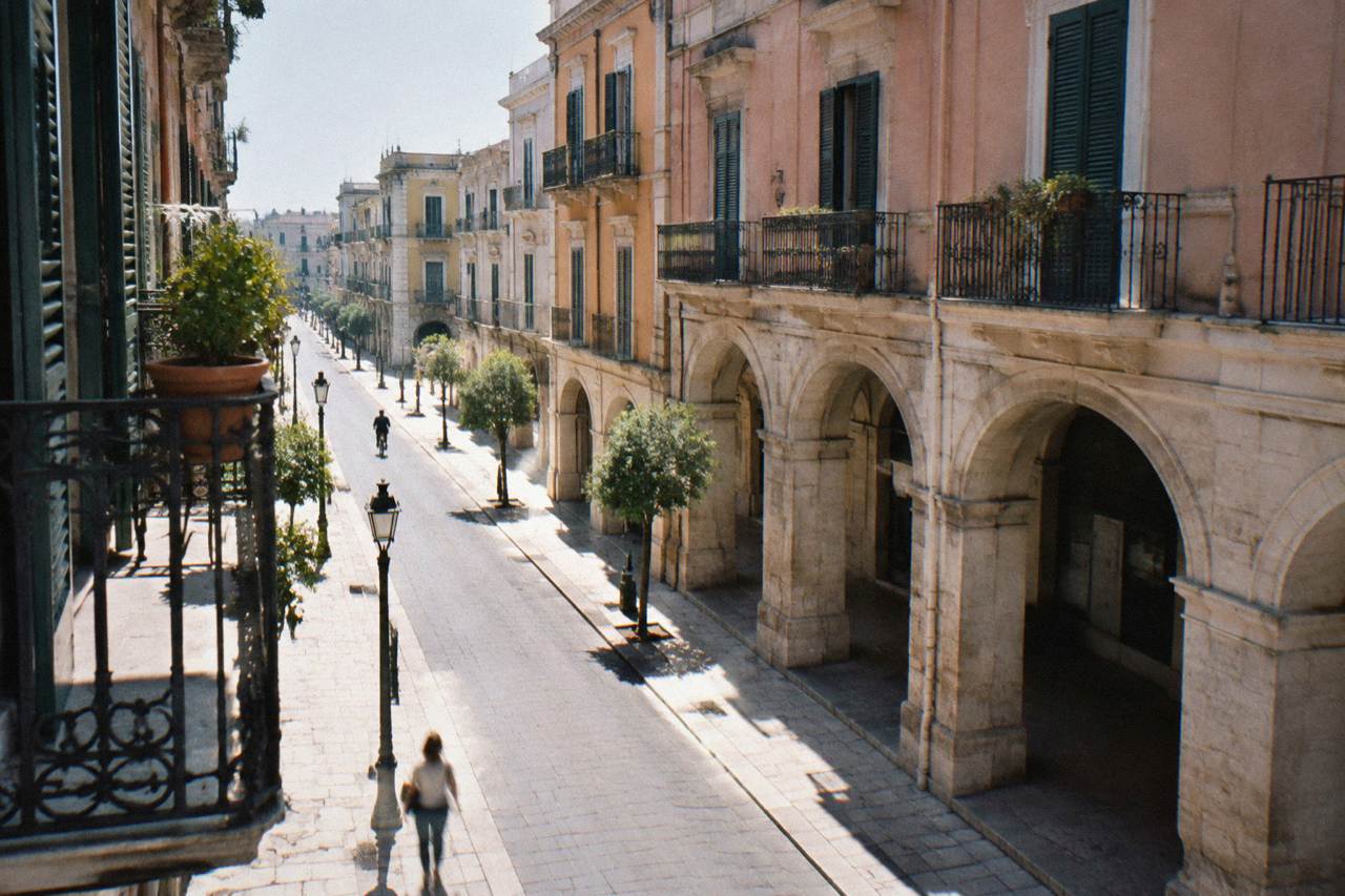Elegant street with wrought-iron balconies and pastel stucco facades on a quiet morning