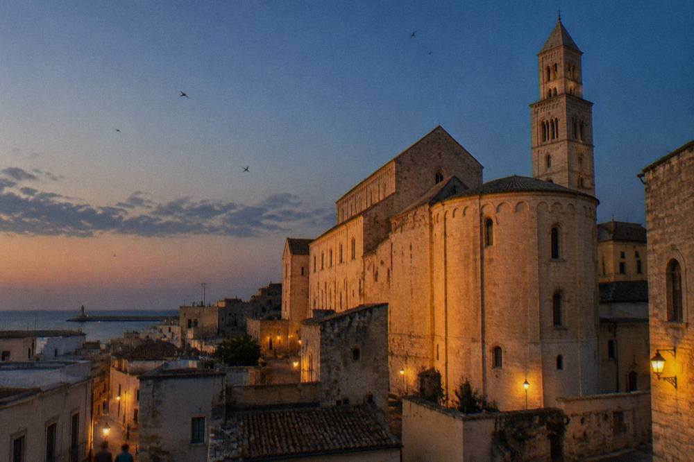 Basilica apse and walls glowing in low evening light above old town rooftops with swifts in the sky
