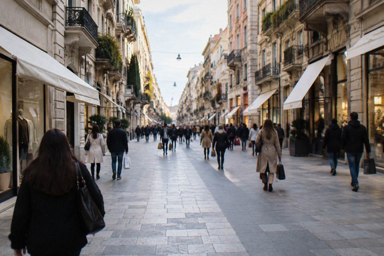 Lively pedestrian shopping street lined with facades with distant shoppers carrying bags