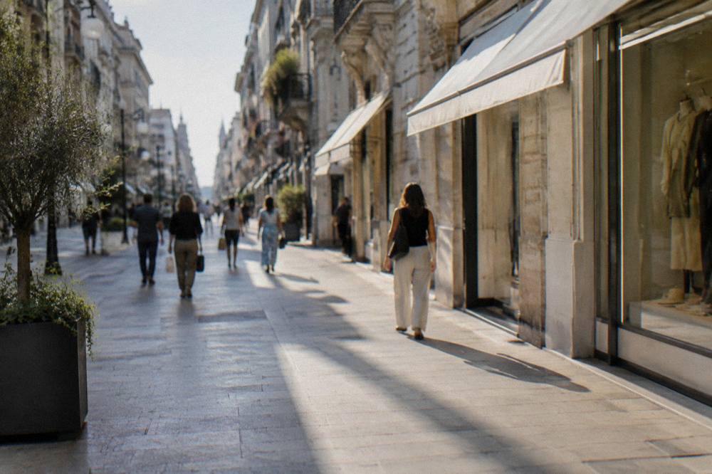 Lively pedestrian shopping street lined with facades with distant shoppers carrying bags