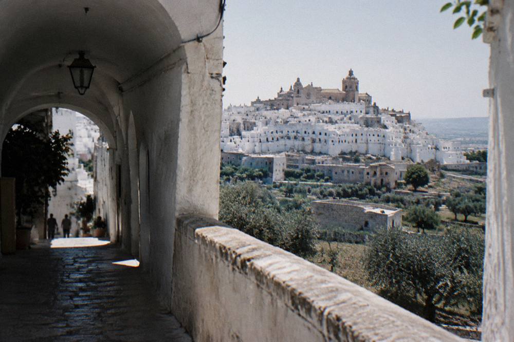 Dazzling white hill town on a ridge above silvery olive groves with a rose-windowed cathedral at the top