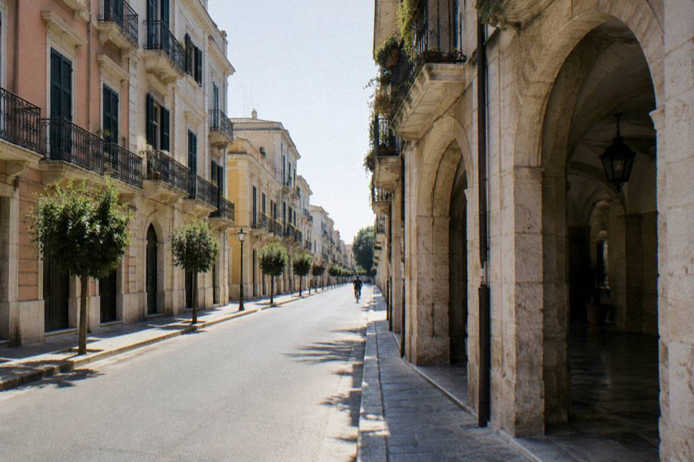 Elegant street with wrought-iron balconies and pastel stucco facades on a quiet morning