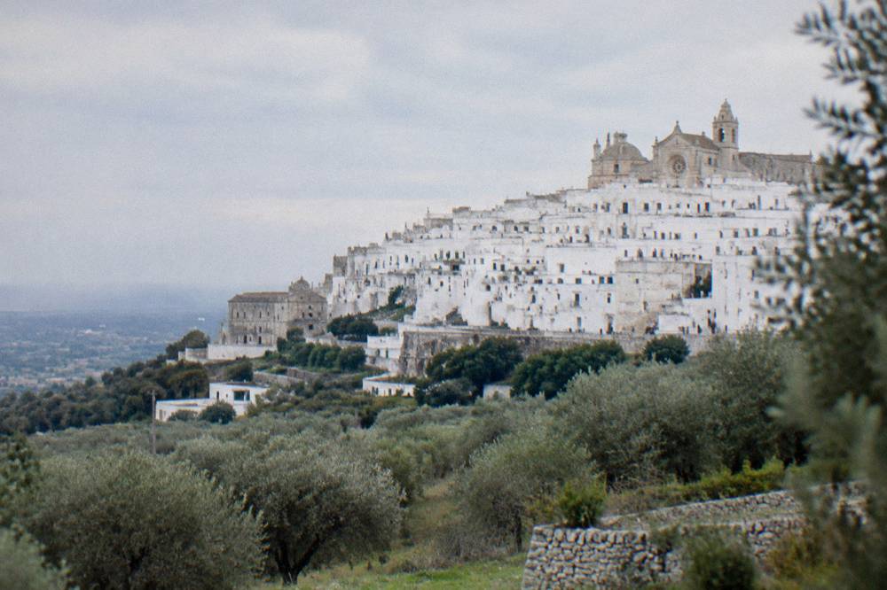 Dazzling white hill town on a ridge above silvery olive groves with a rose-windowed cathedral at the top